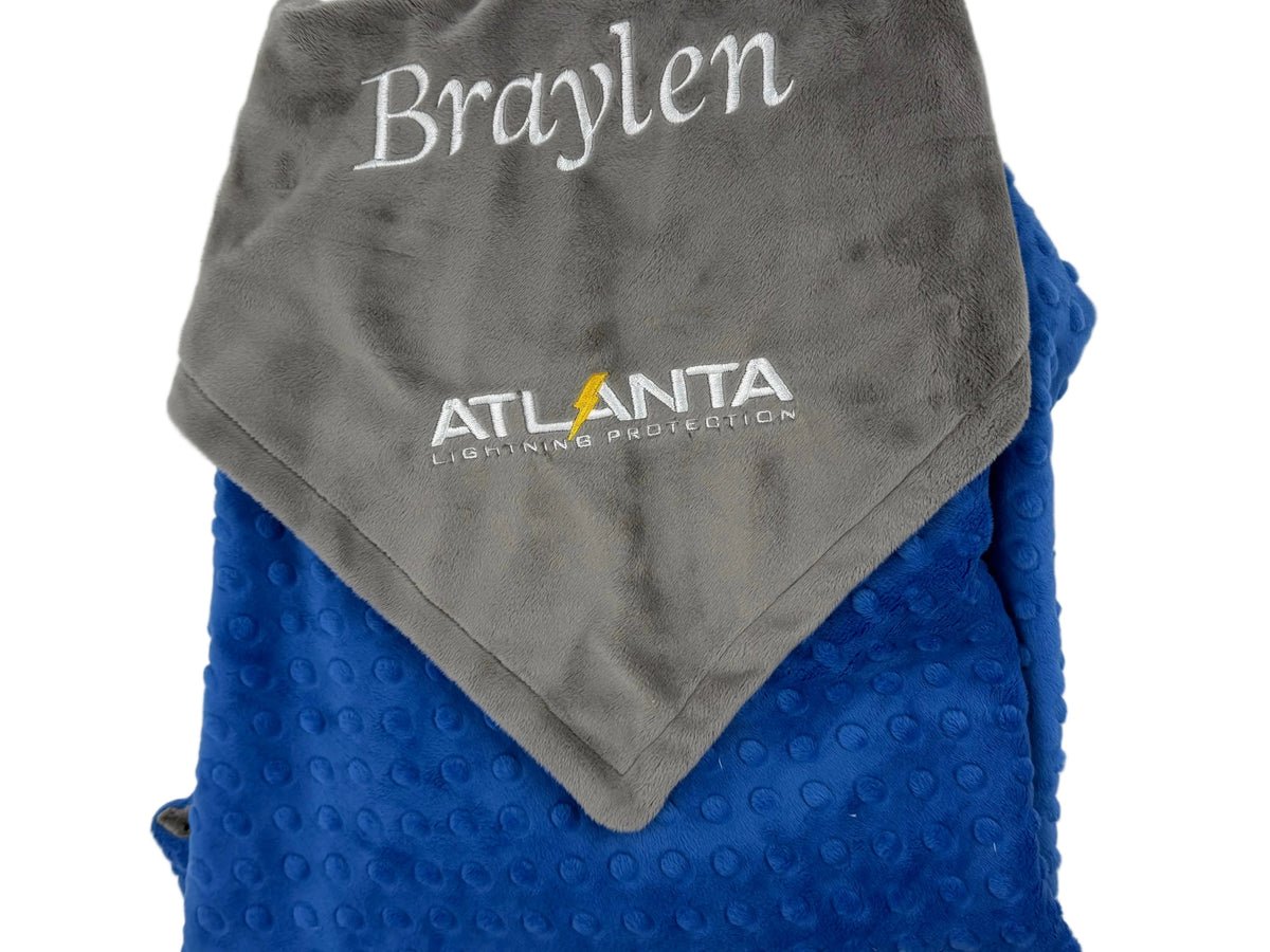 Folded gray and blue blanket with 'Braylen' and 'Atlanta Lightning' branding on a white background