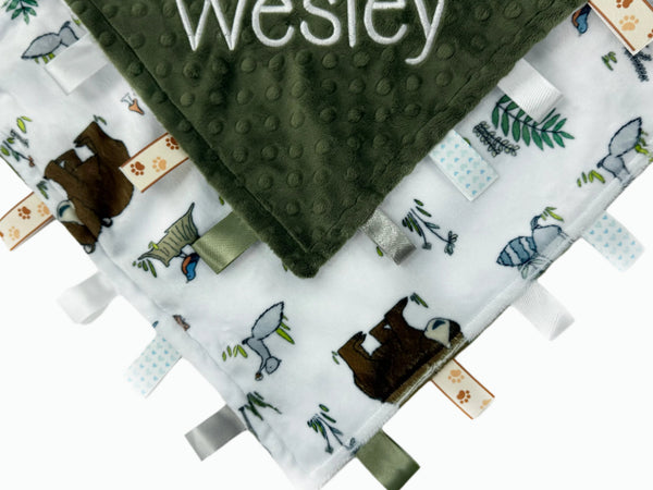 Baby blanket with green minky fabric and animal pattern on a white background