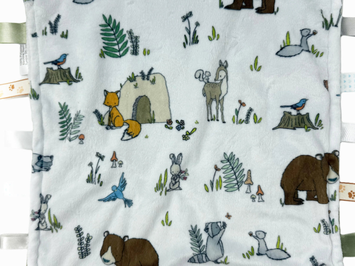 Baby blanket with forest animal illustrations on a white background