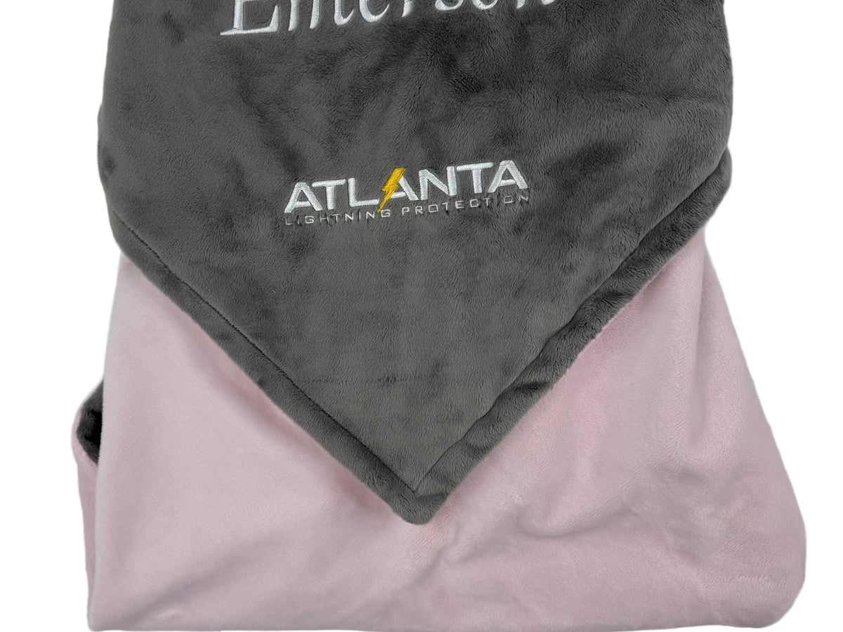 Folded gray and pink blanket with 'Emerson' and 'Atlanta Lightning' branding on a white background