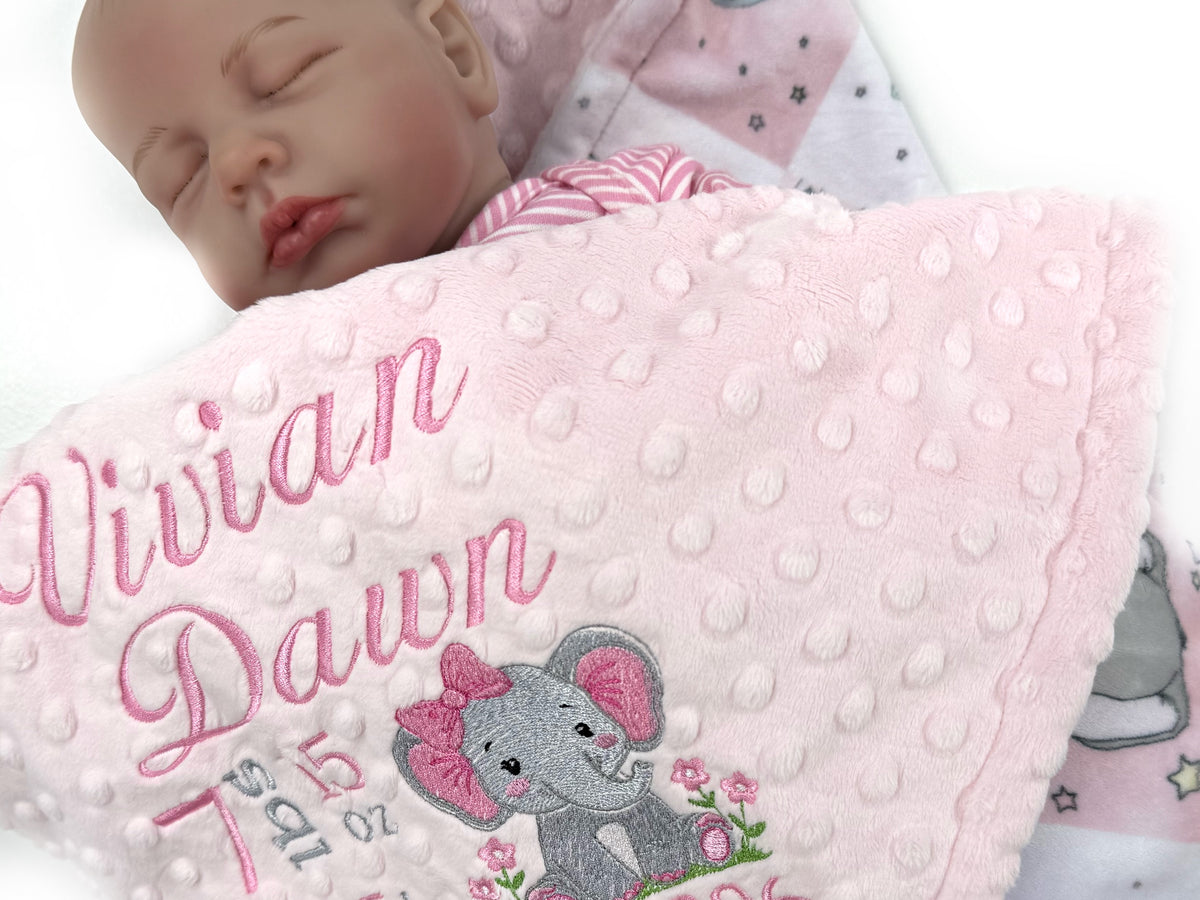 Baby blanket with embroidered text and elephant design, featuring a sleeping baby.