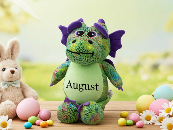 Green dragon plush toy with 'August' embroidered in purple. 