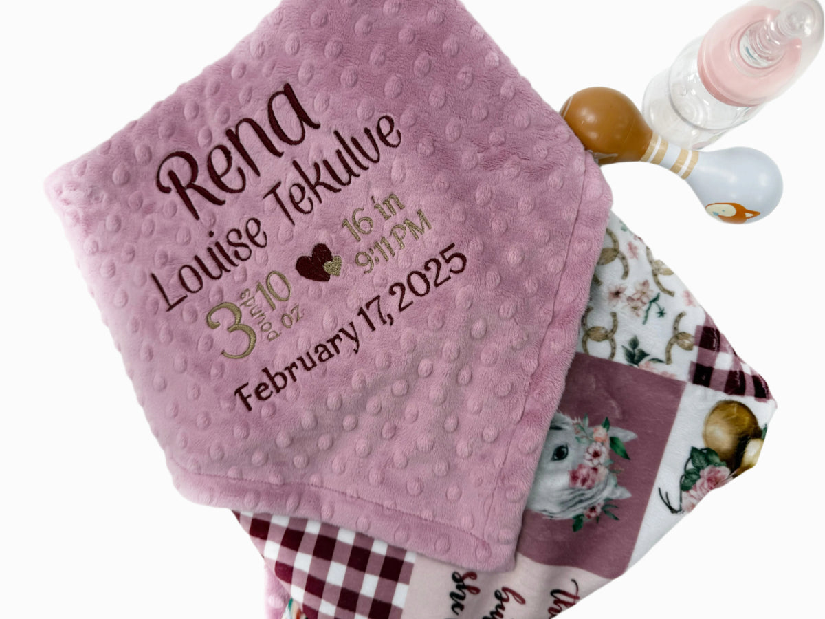 Pink baby blanket with personalized text on a white background