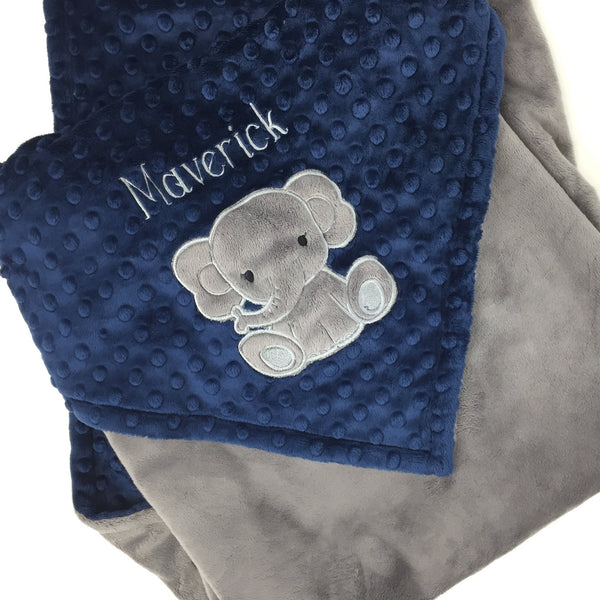 Baby blanket with a gray elephant applique and name in gray. This blanket has navy dimple dot on one side with the elephant and name. The other side is smooth graphite gray minky. This is a beautiful soft blanket for baby to snuggle.