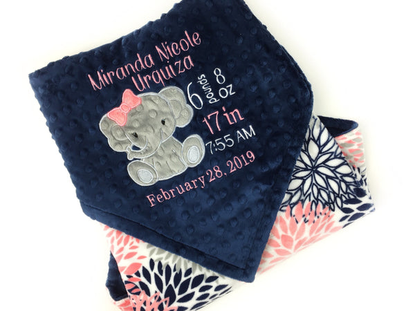 Baby blanket with a gray elephant applique and birth stats in coral and white. Blanket has navy dimple dot on one side with the elephant. The other side is smooth coral and navy floral minky. This is a beautiful soft blanket for baby to snuggle.