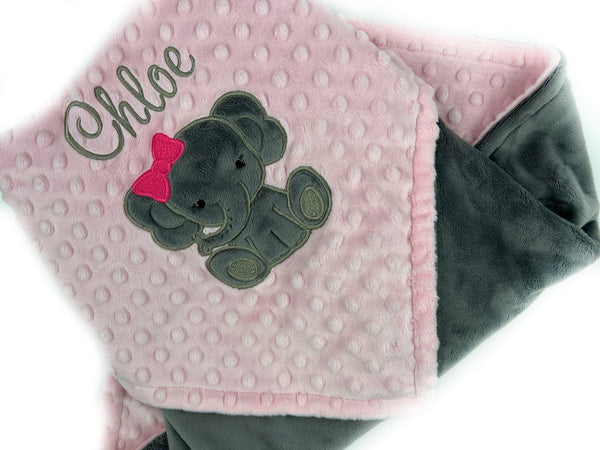 Baby blanket with a gray elephant applique and name in gray. This blanket has blush pink dimple dot on one side with the elephant and name. The other side is smooth graphite gray minky. This is a beautiful soft blanket for baby to snuggle.