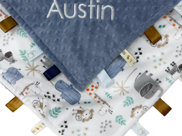Baby blanket with name 'Austin' and fabric tags on a white background