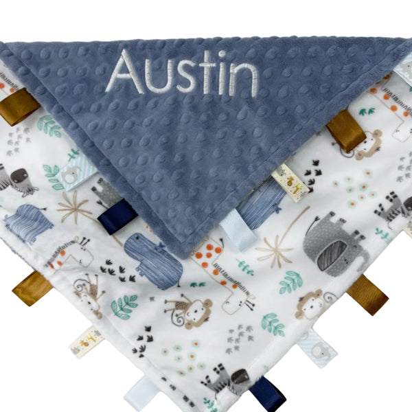 Baby blanket with name 'Austin' and fabric tags on a white background