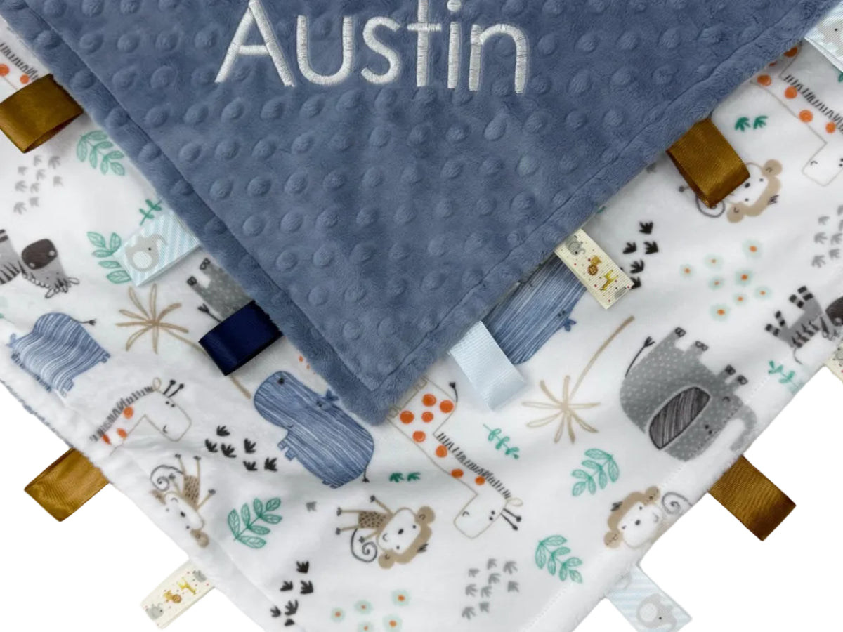 Baby blanket with name 'Austin' and fabric tags on a white background