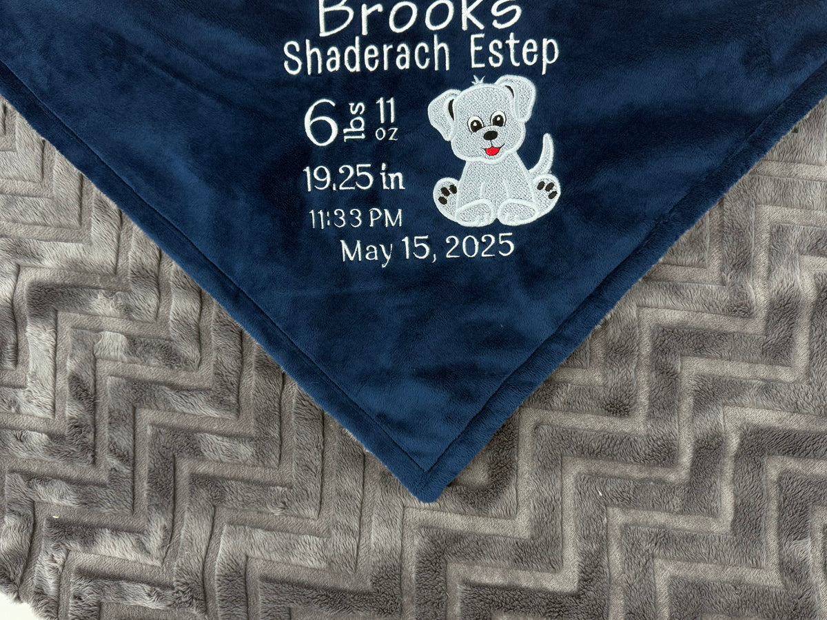 Navy blue and gray blanket with embroidered baby birth stats and a puppy applique in white