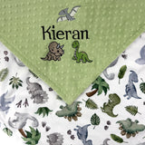 Personalized dinosaur baby blanket with embroidered baby name on sage green dimple minky and colorful dinosaur print backing