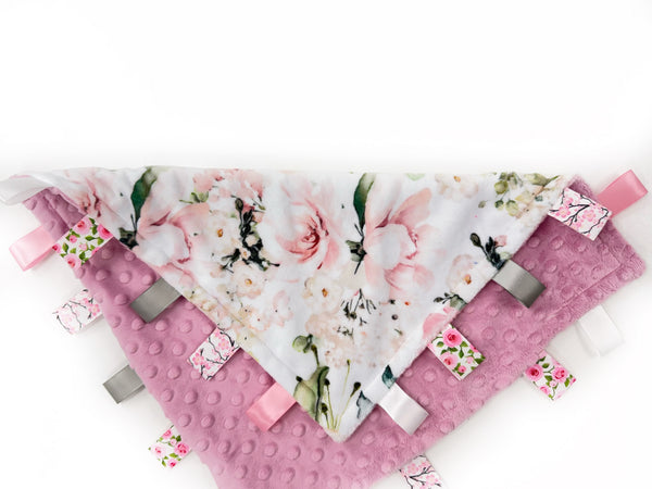 Floral patterned tag blanket with pink accents on a white background