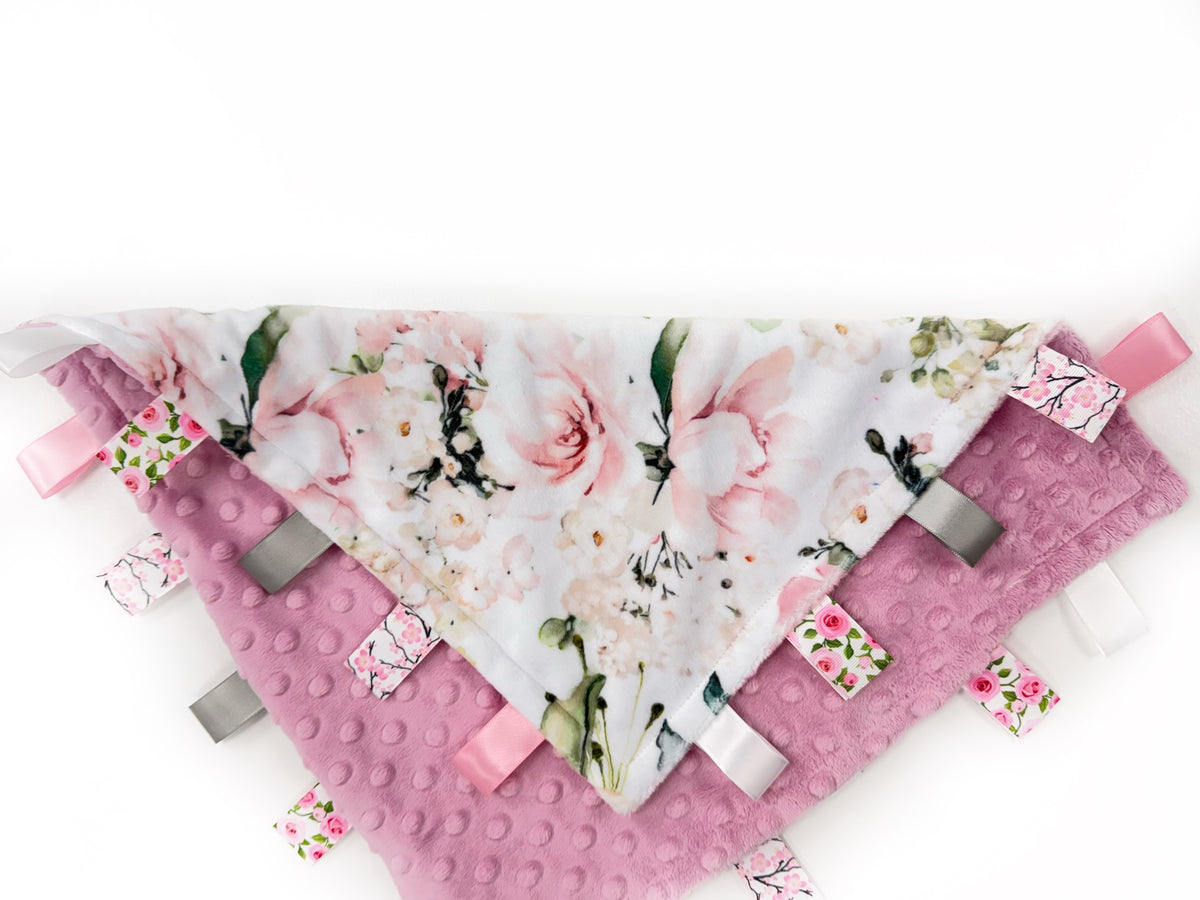 Floral patterned tag blanket with pink accents on a white background