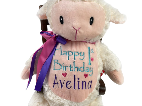 Plush lamb toy with 'Happy 1st Birthday Avelina' text on a white background