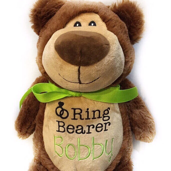 A brown plush teddy bear with a green bow ribbon around its neck, featuring a label with the text 'Ring Bearer Bobby'.